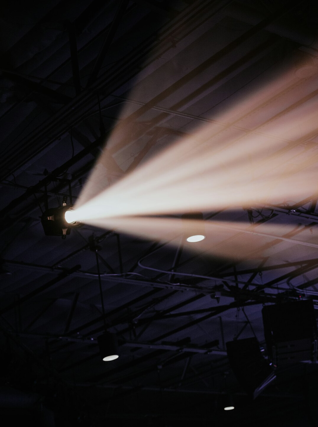 Broadcast camera pointed at a lit studio stage