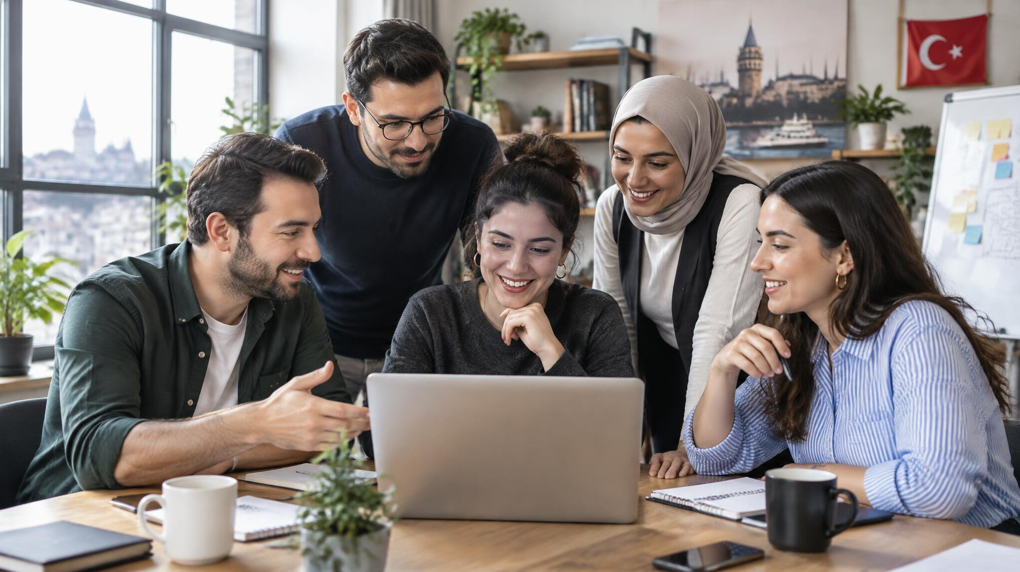 Group of colleagues collaborating around a laptop